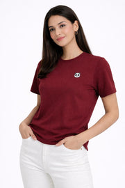 Woman wearing a maroon t-shirt with a small panda logo on a white background